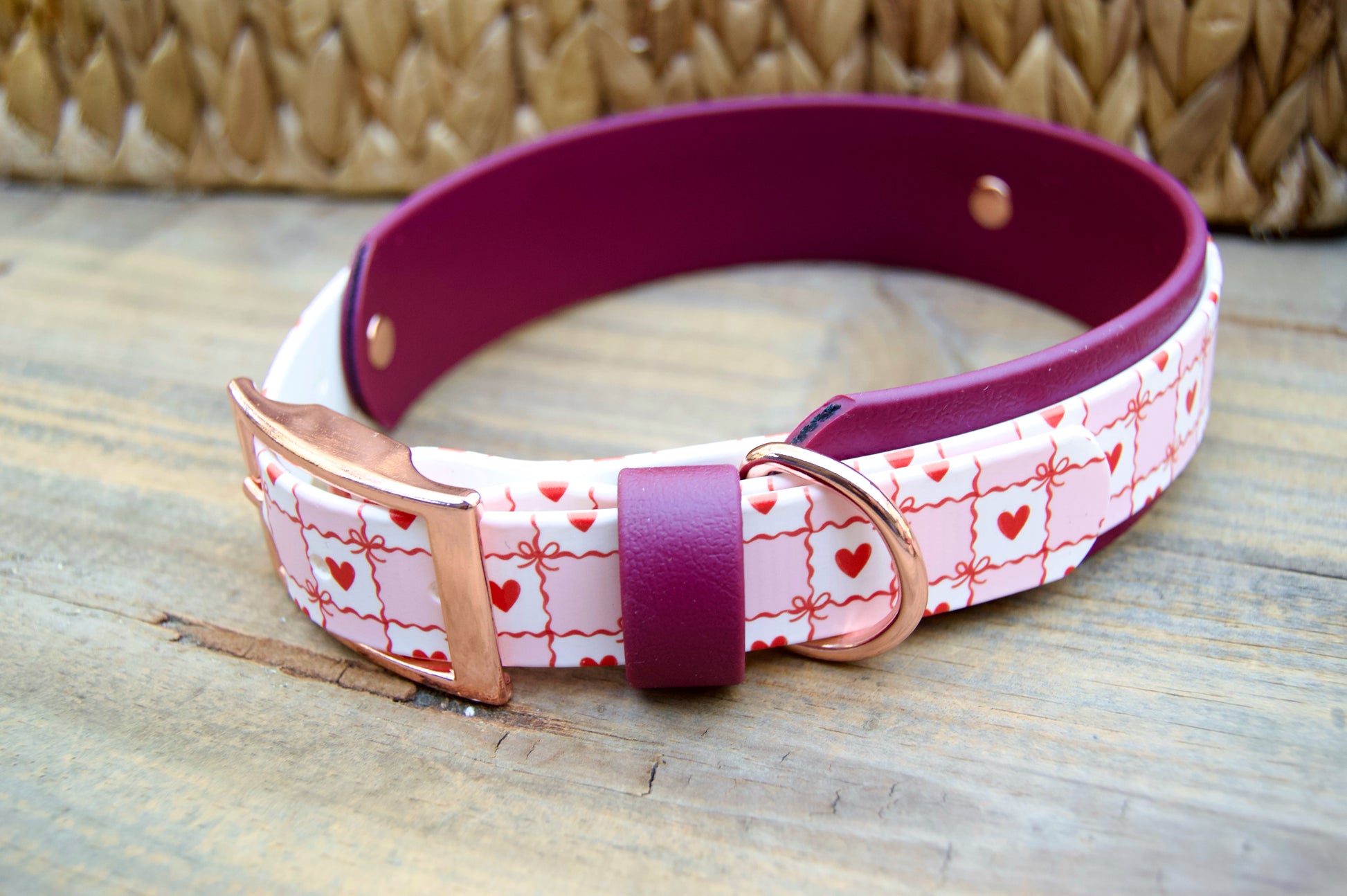 Biothane Dog collar with pink and white pattern and Burgundy accents on a wooden surface