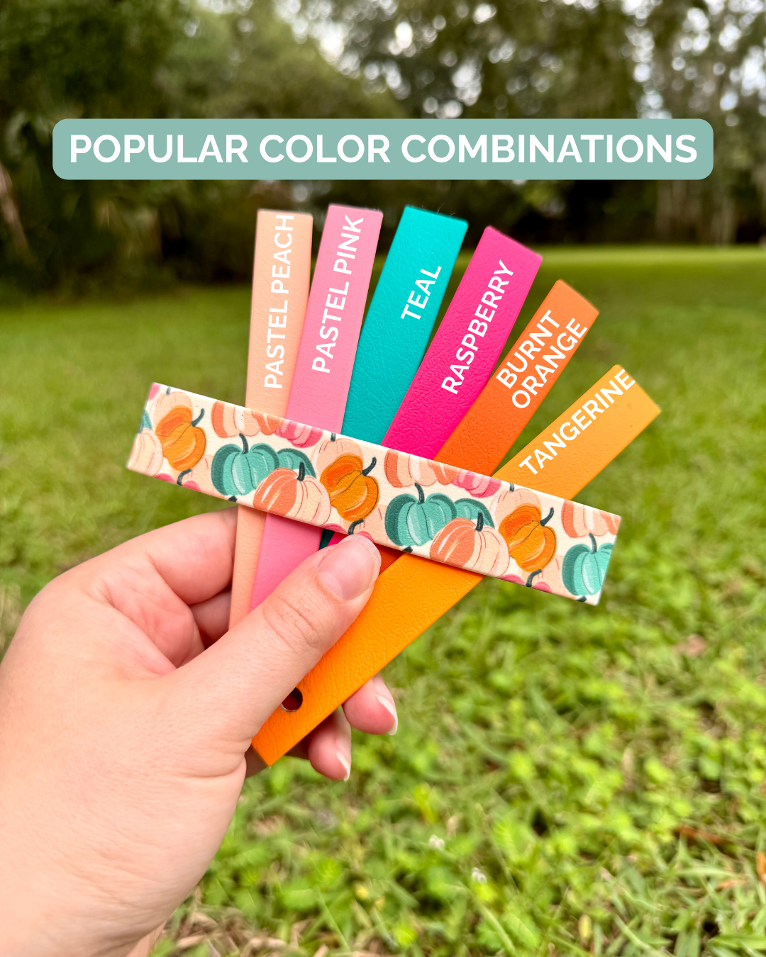Hand holding colorful swatches with Colorful pumpkin design against a grassy background