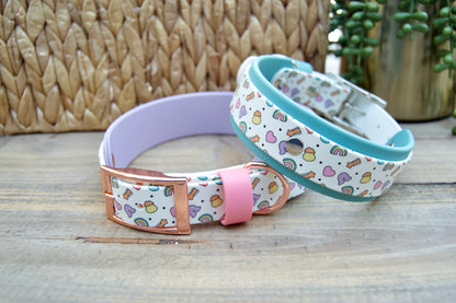 Two colorful dog collars on a wooden surface with a woven basket and plant in the background.