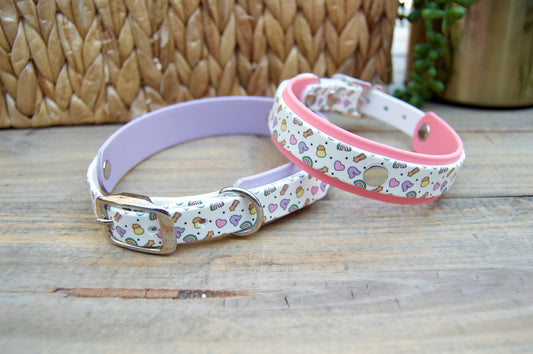 Two lucky charm patterned dog collars on a wooden surface with a woven basket in the background.