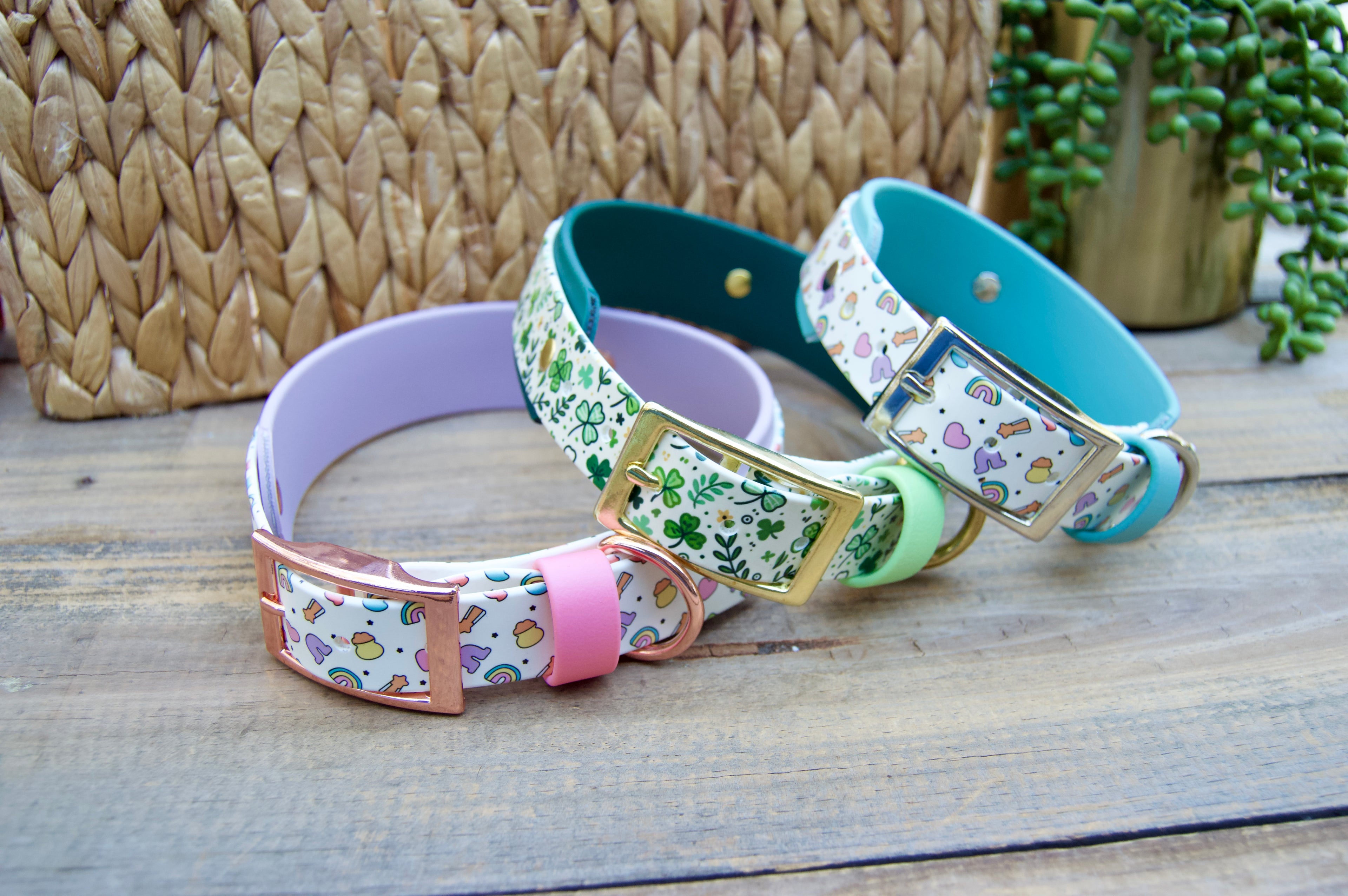 Set of colorful dog collars with patterned bands on a wooden surface.