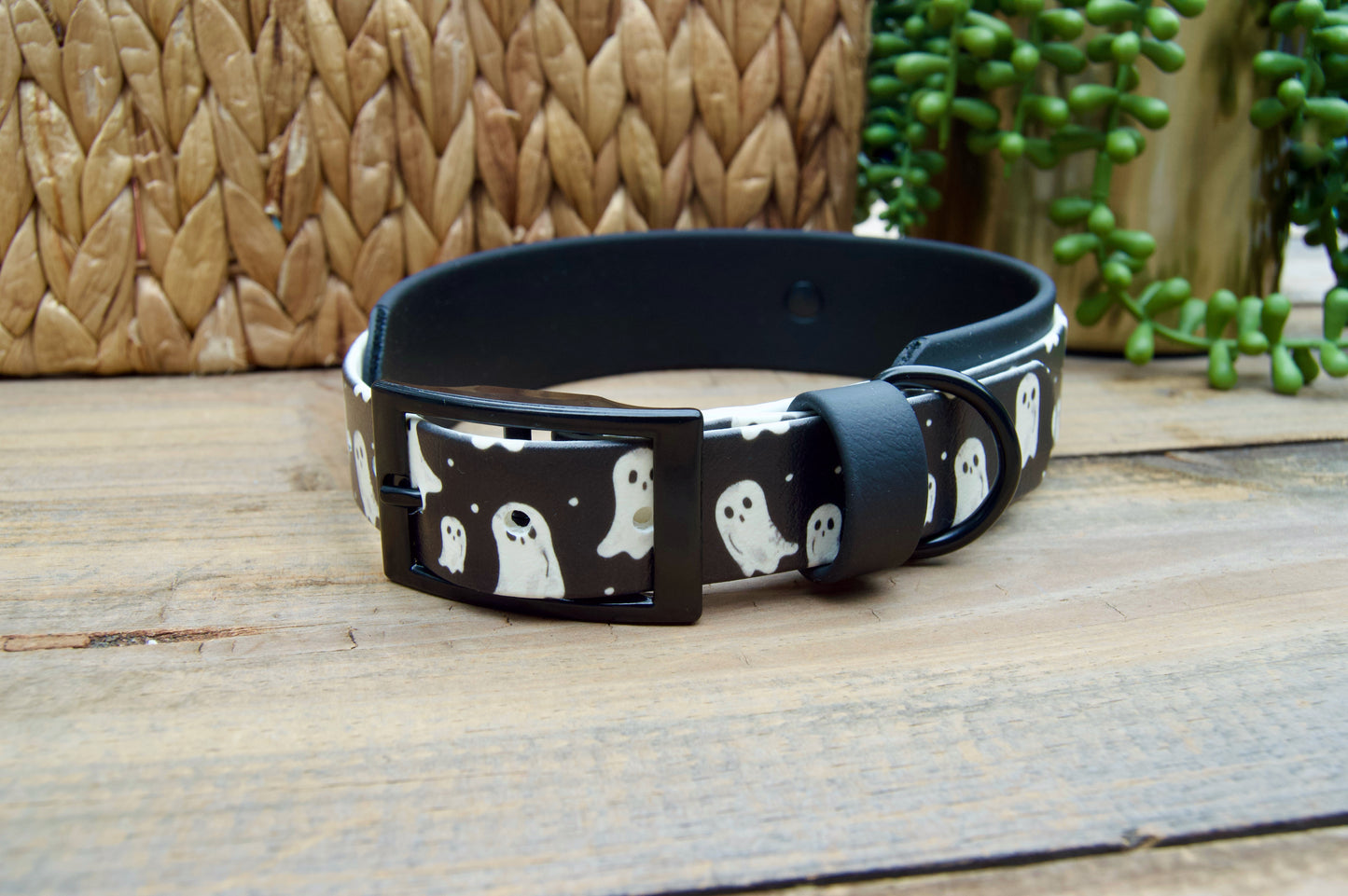 Black dog collar with ghost pattern on a wooden surface