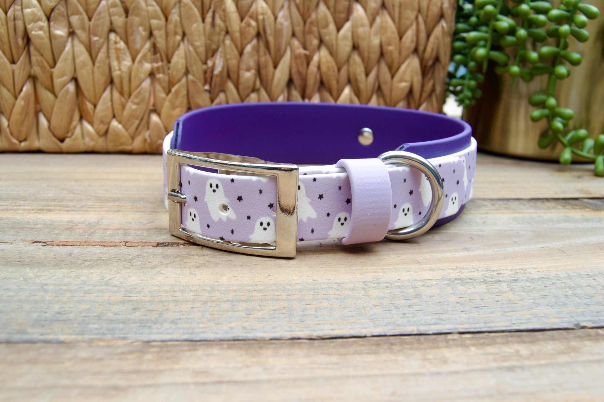 Dog collar with purple band with white ghosts and tiny black stars pattern on a wooden surface