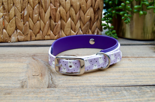 Purple Dog collar with white ghosts and black stars on a wooden surface