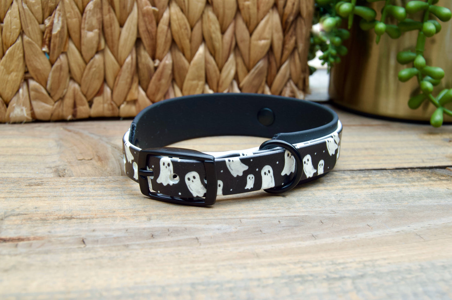 Black dog collar with ghost pattern on a wooden surface