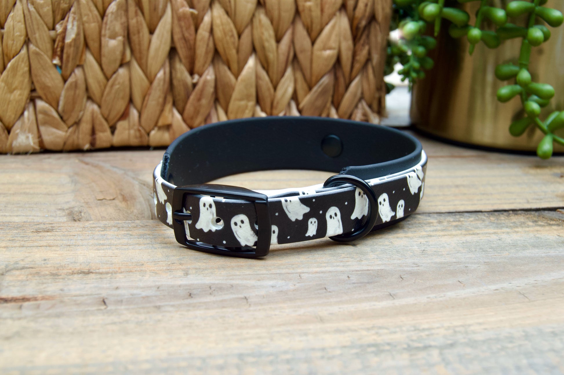 Black dog collar with ghost pattern on a wooden surface