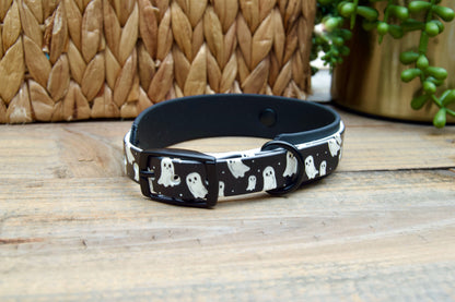 Black dog collar with ghost pattern on a wooden surface