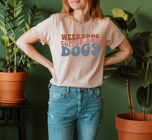 T-shirt that says 'Weekends Coffee and Dogs' is light red and blue letters on a light pink shirt. 