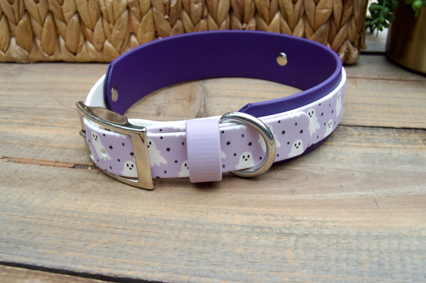 Dog collar with purple band and white ghosts patterned on a wooden surface
