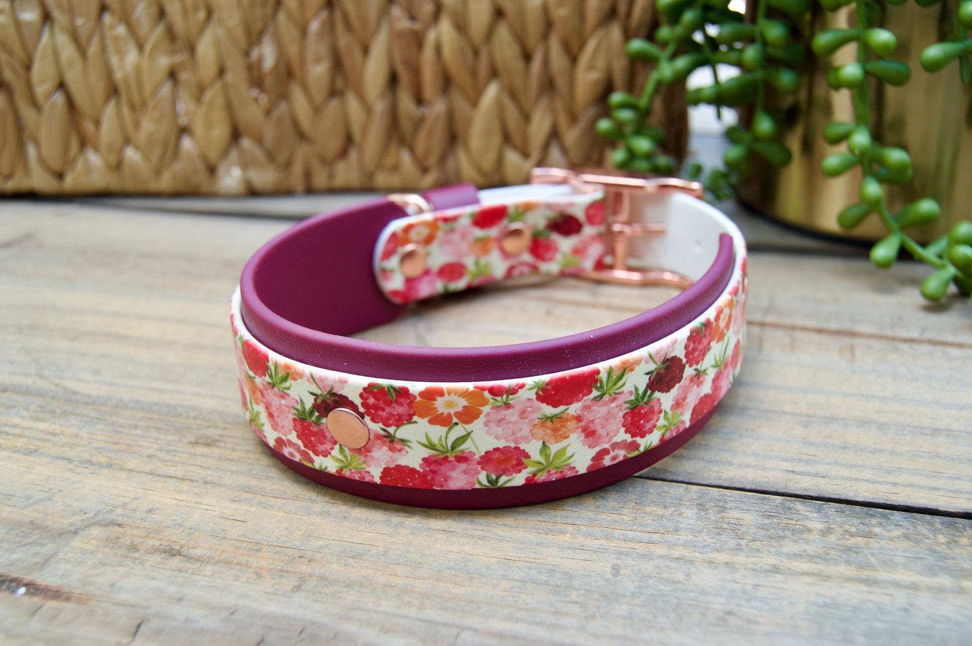 raspberry patterned dog collar with a burgundy accents on a wooden surface